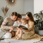 a family sitting on floor reading a book
