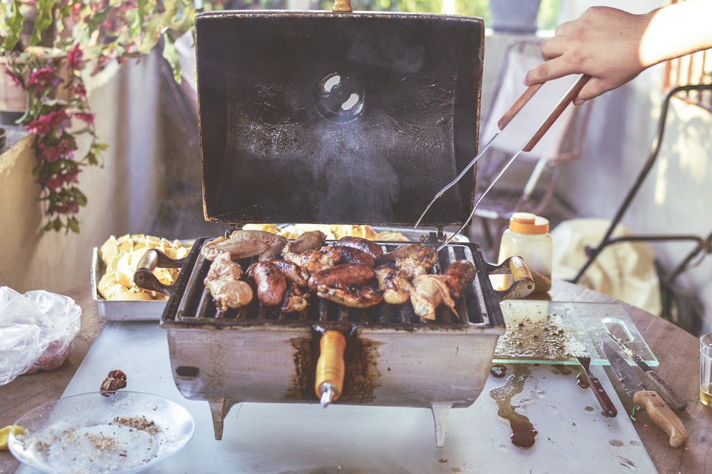 Grilled meats and vegetables cooking on an outdoor barbecue grill. Perfect for summer gatherings.
